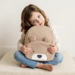 Bambina stringe tra le braccia zainetto a forma di orsetto colore marrone nocciola