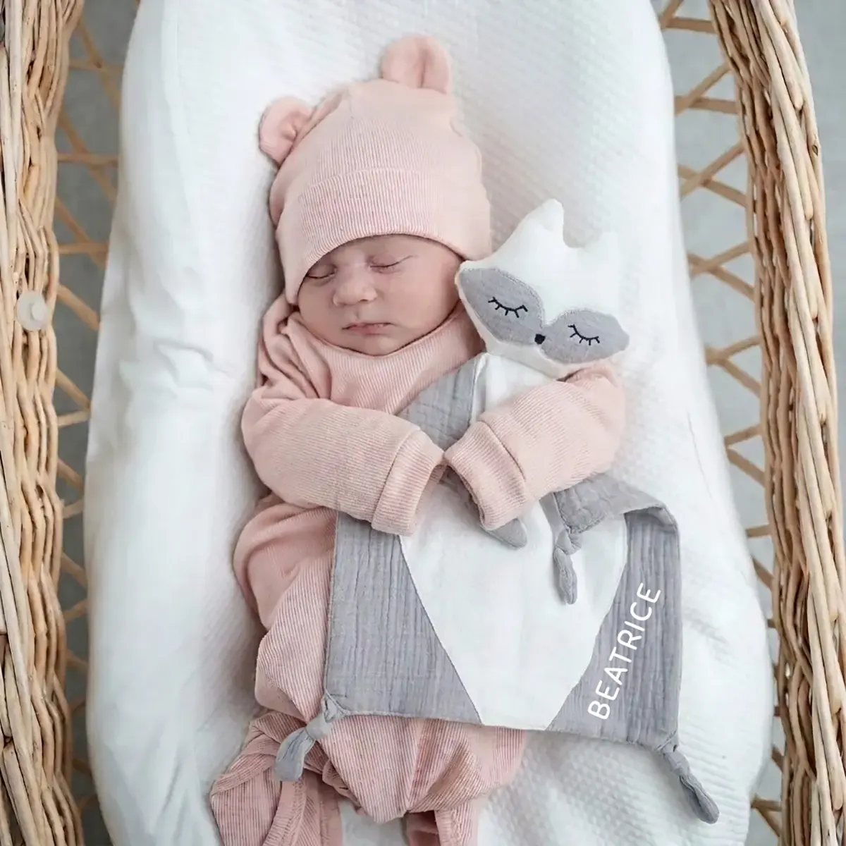 Neonato stringe il doudou volpe grigio in mussola di cotone