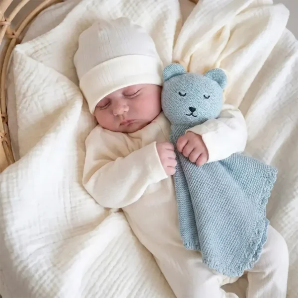 Neonato tiene il doudou in maglia azzurro