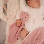 Neonato tiene il doudou in maglia rosa
