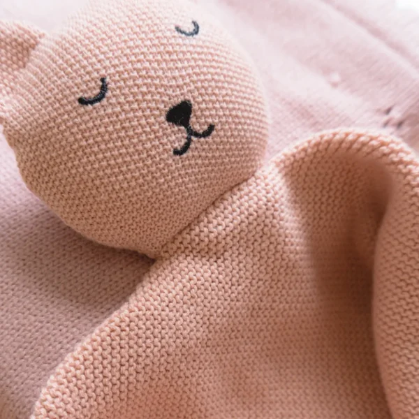 Dettaglio della copertina e del doudou in maglia del kit rosa sorbetto