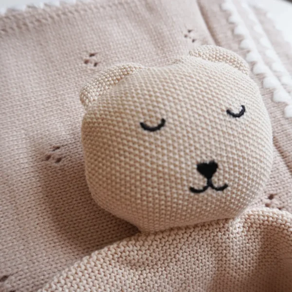 Dettaglio della copertina e del doudou in maglia beige del kit regalo nascita