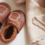 Dettaglio scarpine per gattonare con ricamo gufo in pelle naturale e doudou in maglia di cotone inclusi nel kit regalo nascita