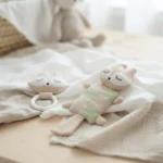 Dettaglio sonaglio e anello dentizione del set nascita personalizzato beige