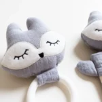 Set nascita personalizzato grigio chiaro: dettaglio del sonaglio e anello dentizione coordinati
